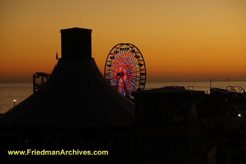 amusement park,ferris wheel,neon,LED,lights,sunset,orange,silhouette,California,pier,tourist,
