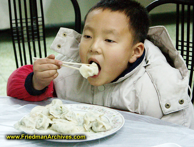 Asian Baby Eating Dumplings by Stocksy Contributor ChaoShu Li